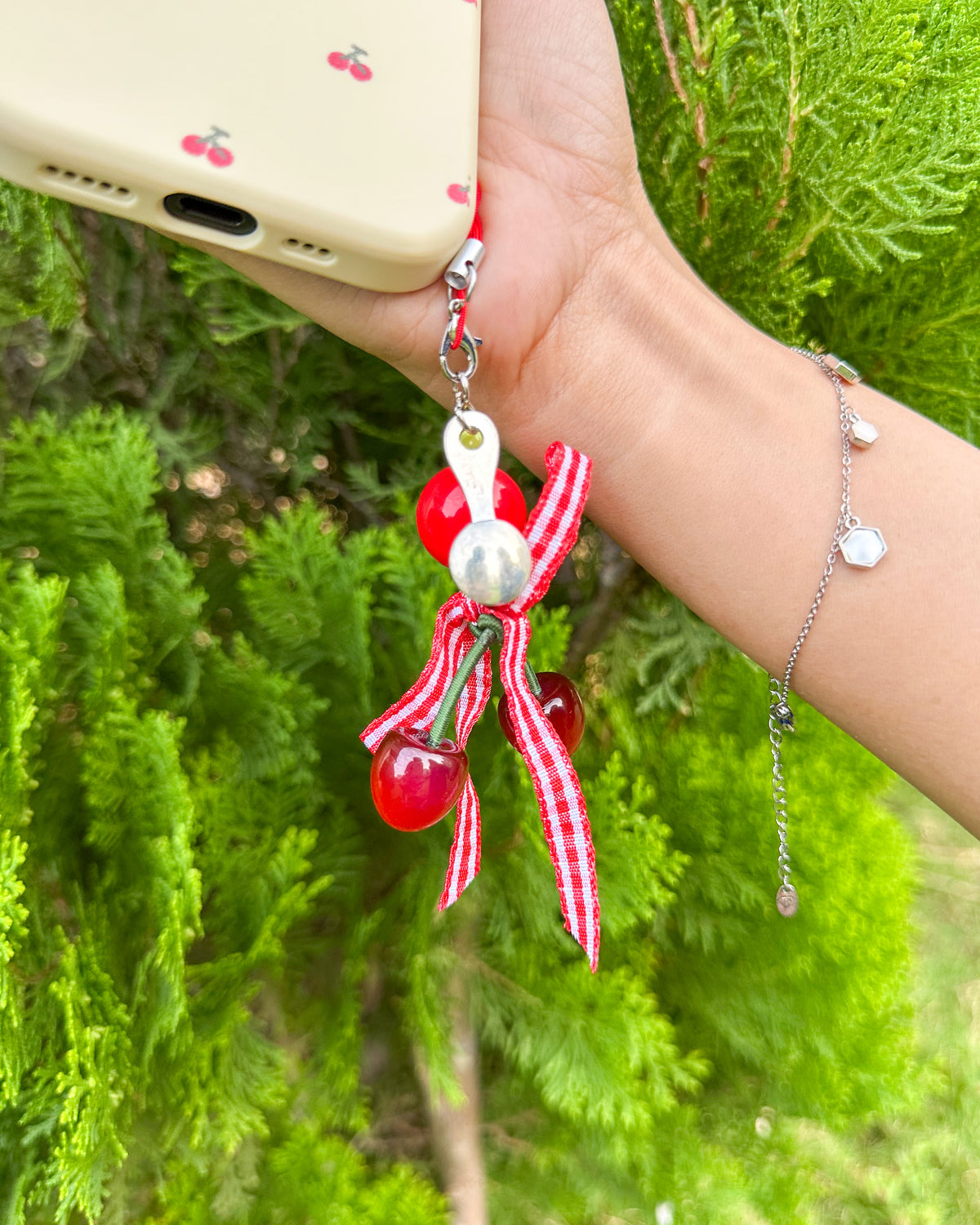 Cherry charm with pearl and gingham bow attached to the TOKFO Cherry phone case