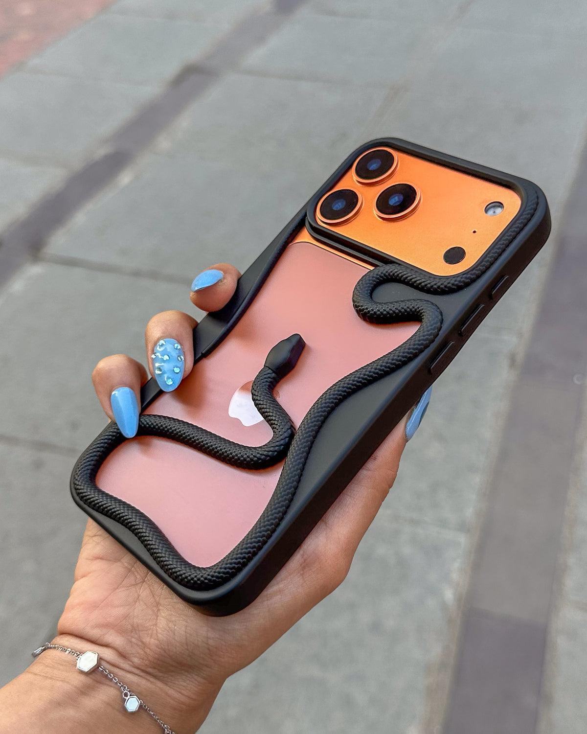 Black TOKFO Snake phone case held at an angle showing the raised camera edges and 3D snake