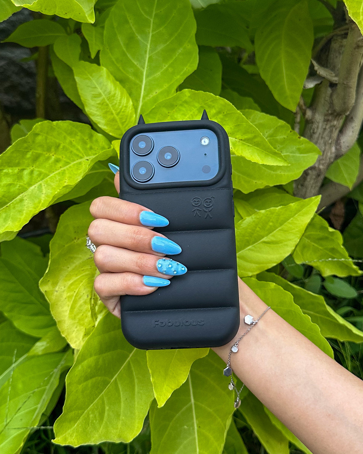 TOKFO Puffer Devil Horn iPhone phone case in black with 3D devil horns on the camera ring, held in hand