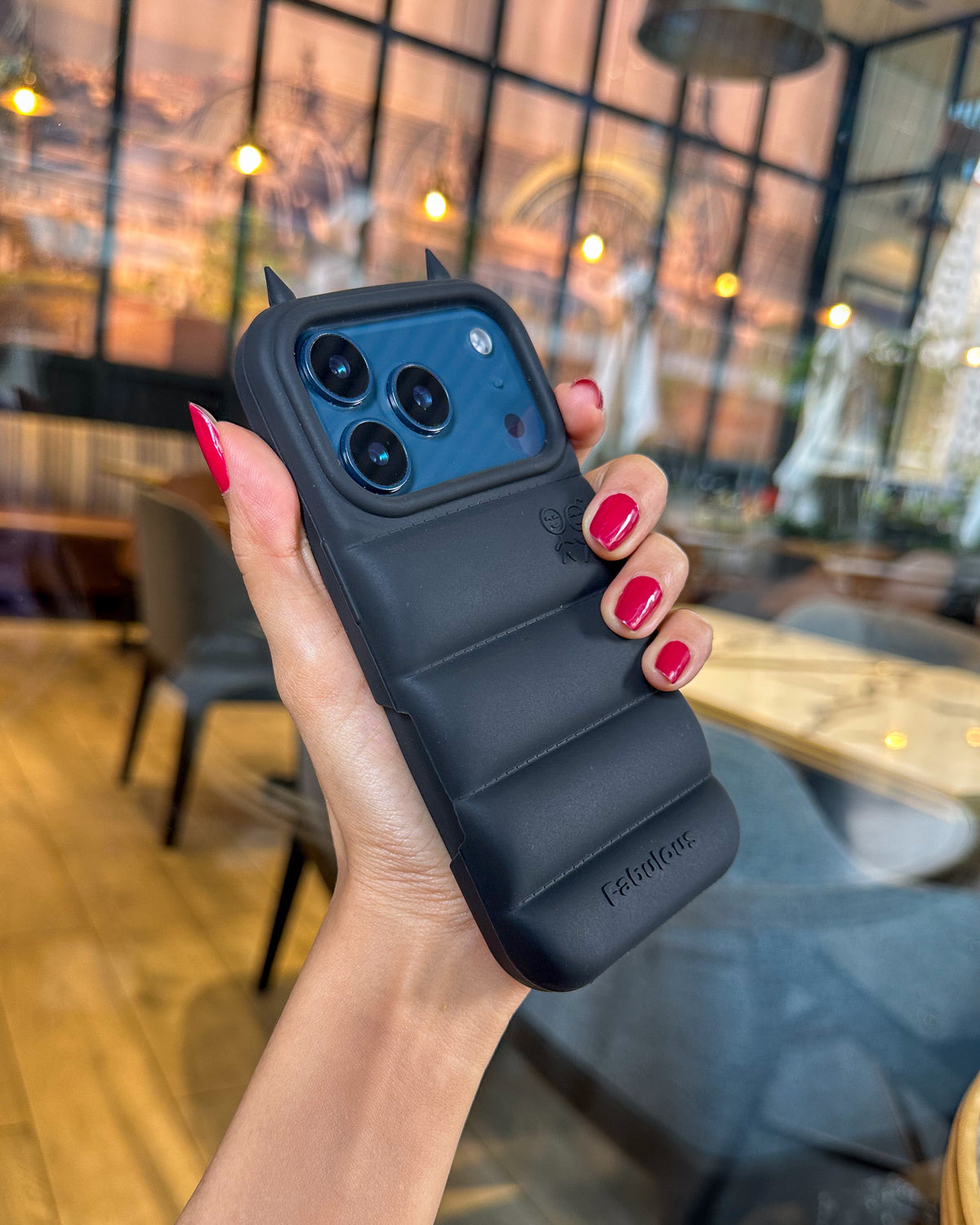 Black TOKFO Puffer Devil Horn phone case held at an angle showing the puffer pattern
