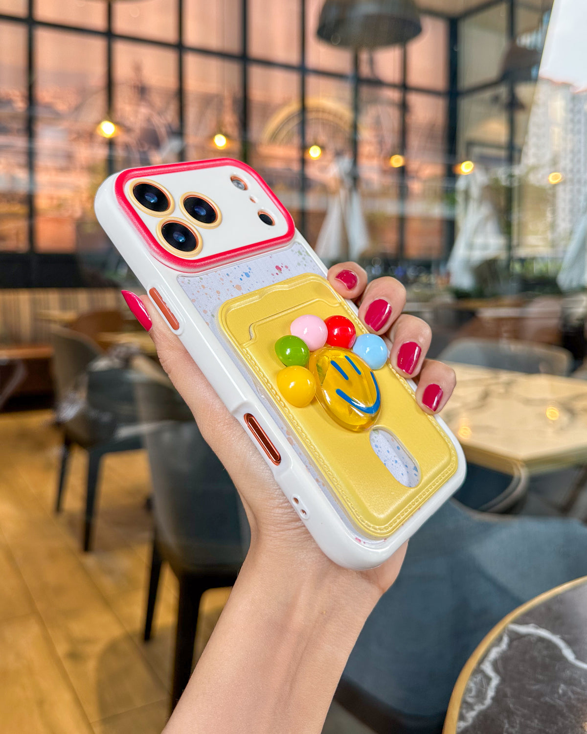 TOKFO Smiley phone case held at an angle showing the 3D smiley face and colourful balls