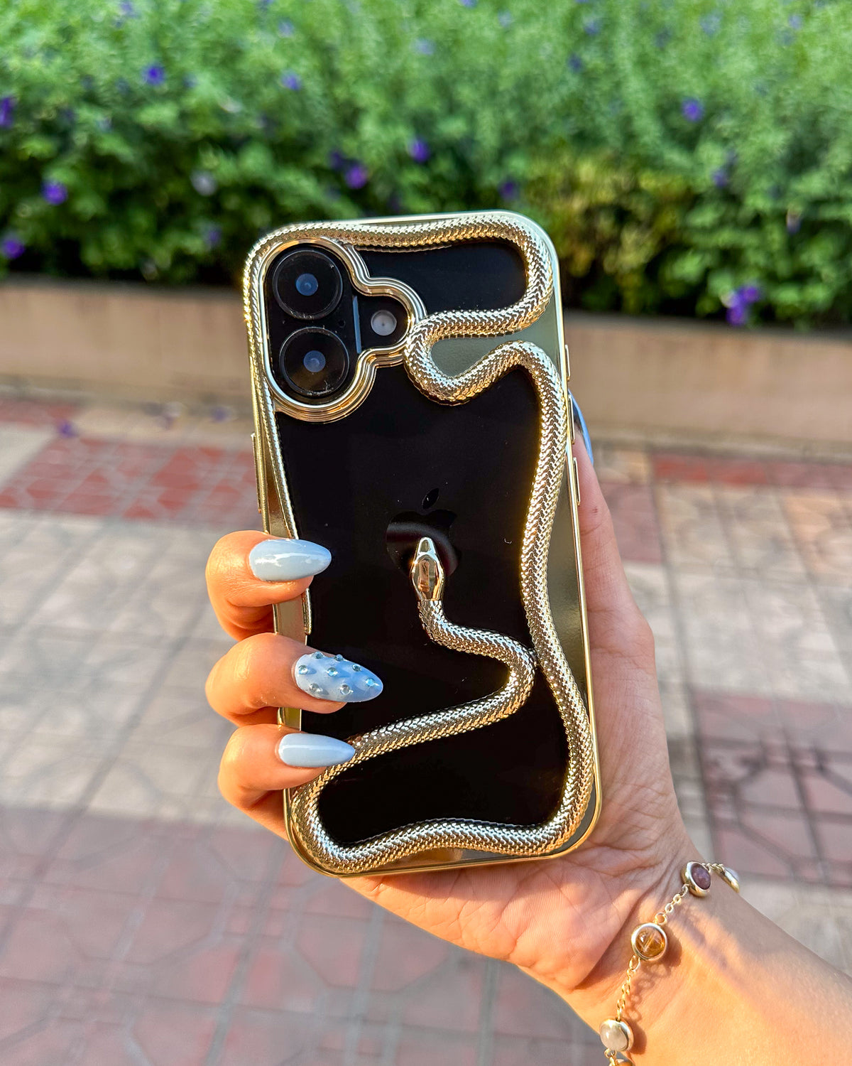 Golden TOKFO Snake bumper phone case on a black iPhone, showing the 3D snake wrapped around the frame