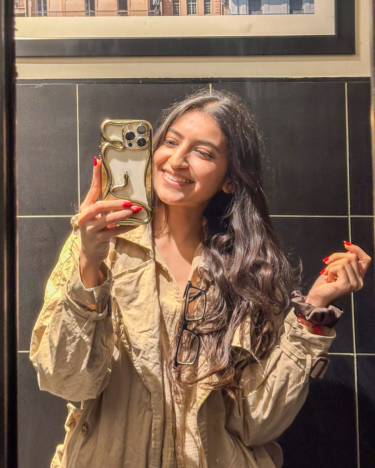 Golden TOKFO Snake open-back iPhone bumper phone case with 3D snake design, held up for a selfie